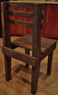 Achterkant van deze stoel die gemaakt is van pallethout en sloophout.